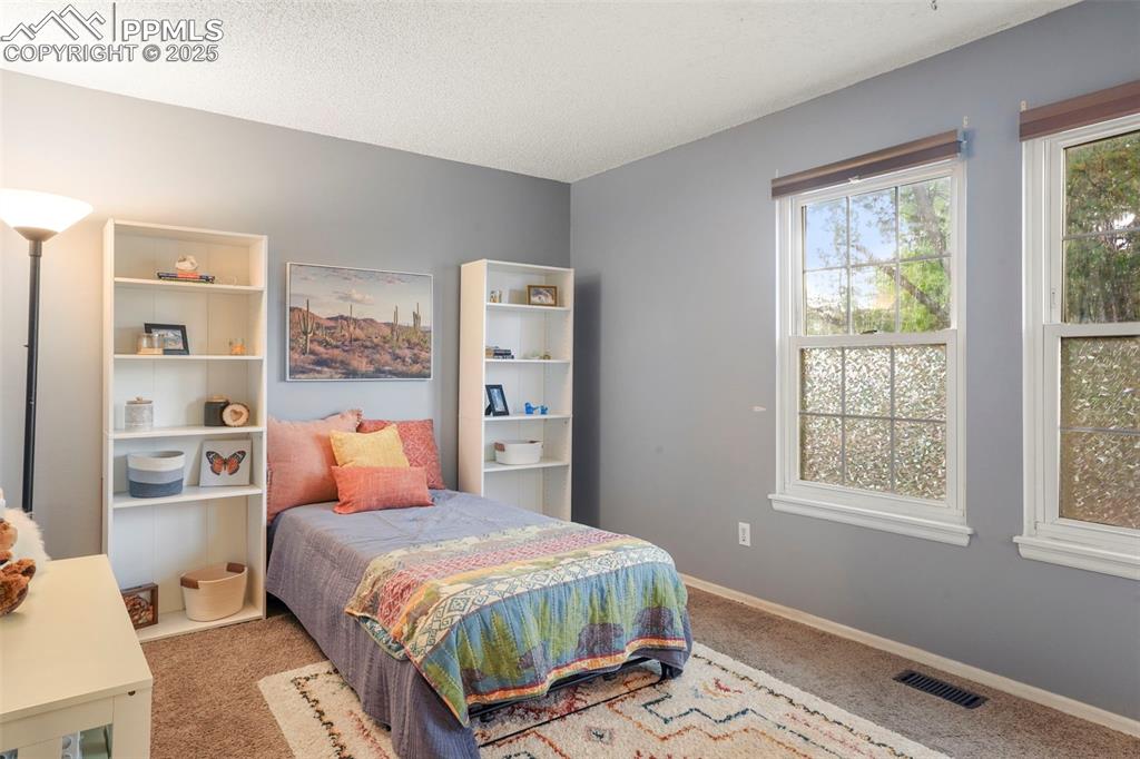 2417 Ranch Lane Colorado Springs, CO 80918 - Photo 14 of 32 a bedroom with a bed and a window