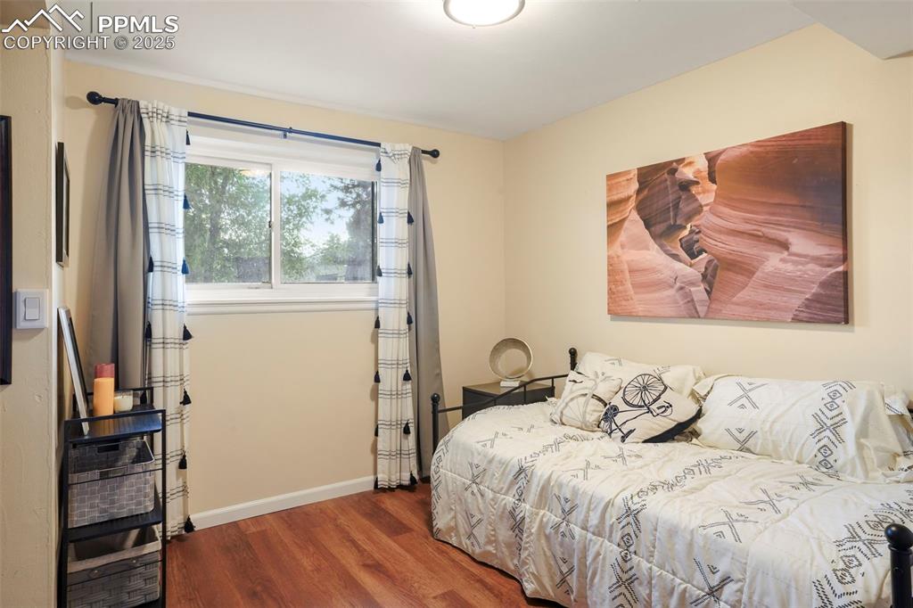 2417 Ranch Lane Colorado Springs, CO 80918 - Photo 19 of 32 a bedroom with a bed and a window with wooden floor