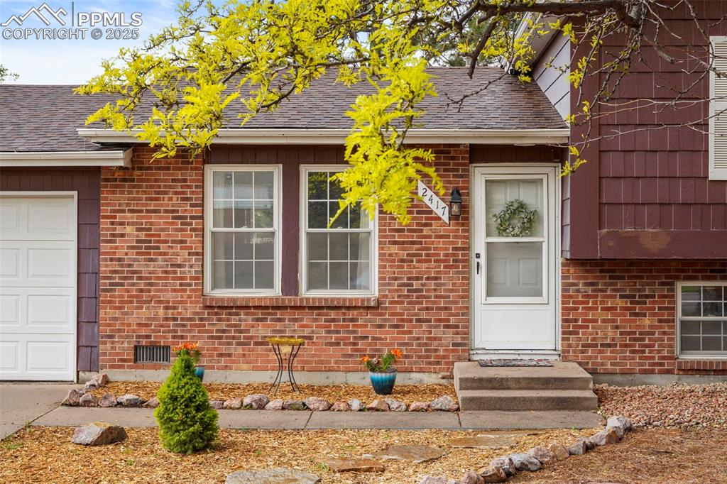 2417 Ranch Lane Colorado Springs, CO 80918 - Photo 2 of 32 a front view of a house with a garden