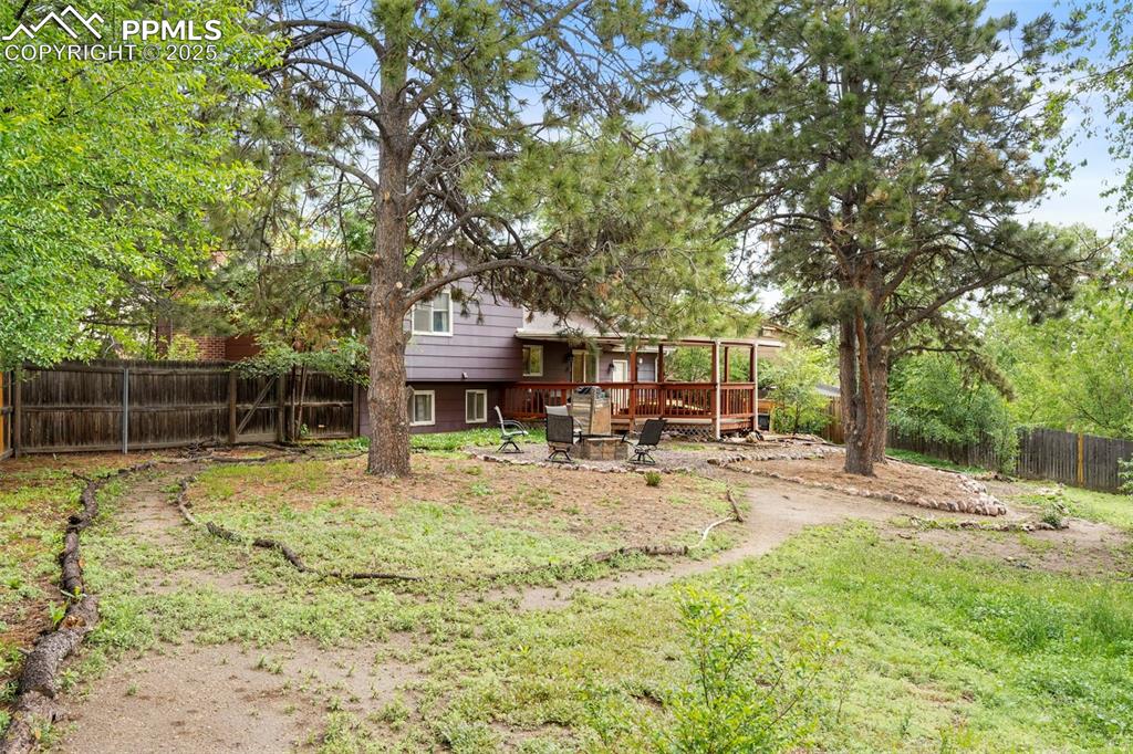 2417 Ranch Lane Colorado Springs, CO 80918 - Photo 25 of 32 a view of a yard with table and chairs under an umbrella