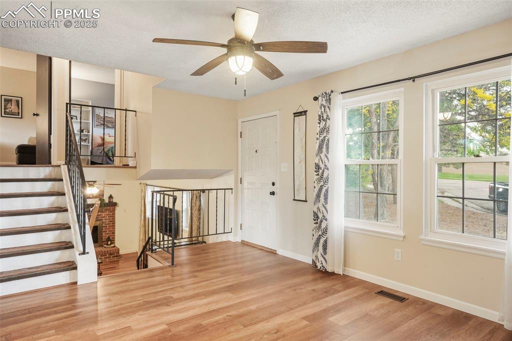 2417 Ranch Lane Colorado Springs, CO 80918 - Photo 3 of 32 a view of a livingroom with wooden floor and a ceiling fan