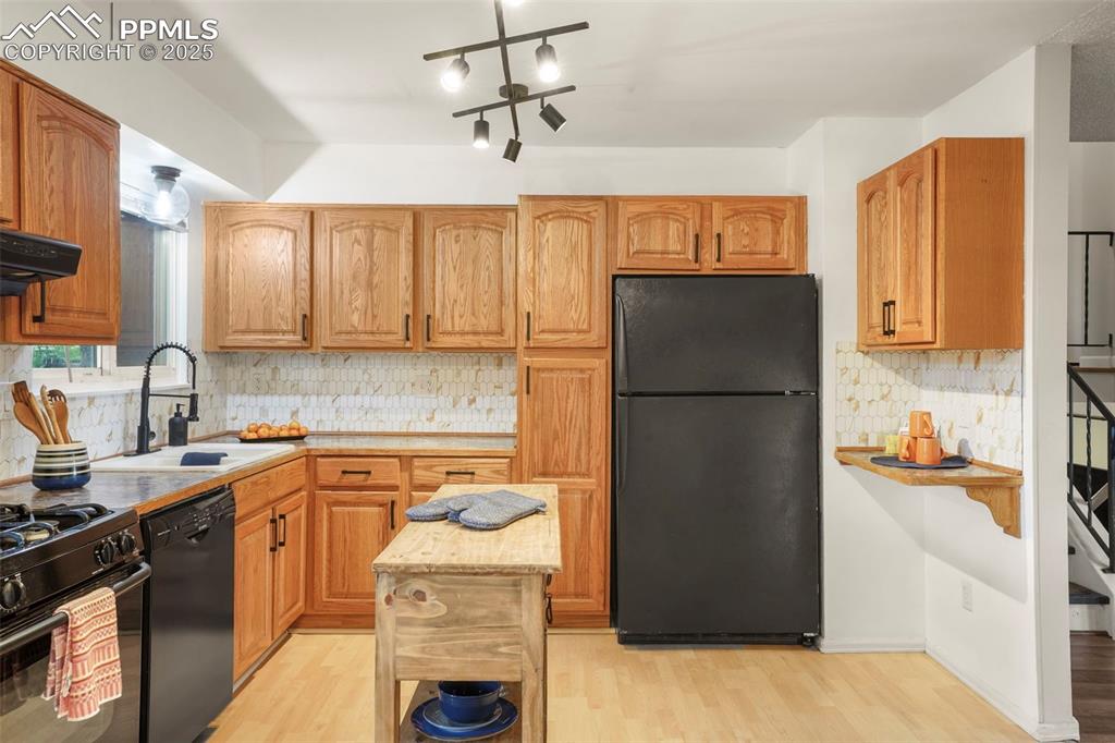 2417 Ranch Lane Colorado Springs, CO 80918 - Photo 7 of 32 a kitchen with a refrigerator and a sink