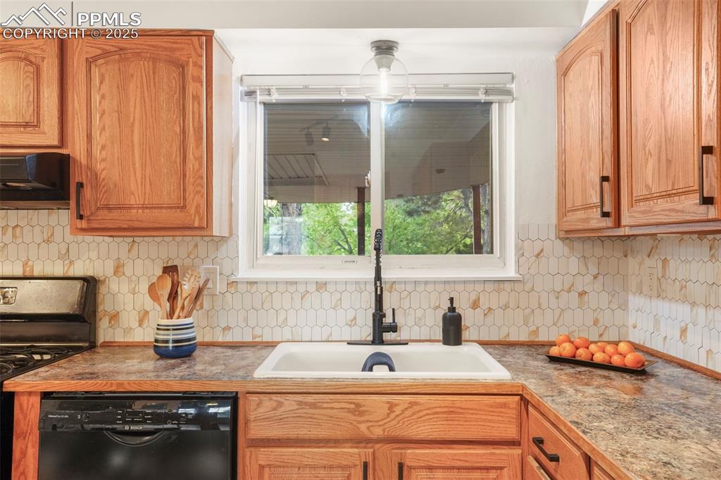 2417 Ranch Lane Colorado Springs, CO 80918 - Photo 9 of 32 a kitchen with granite countertop a sink a stove and cabinets