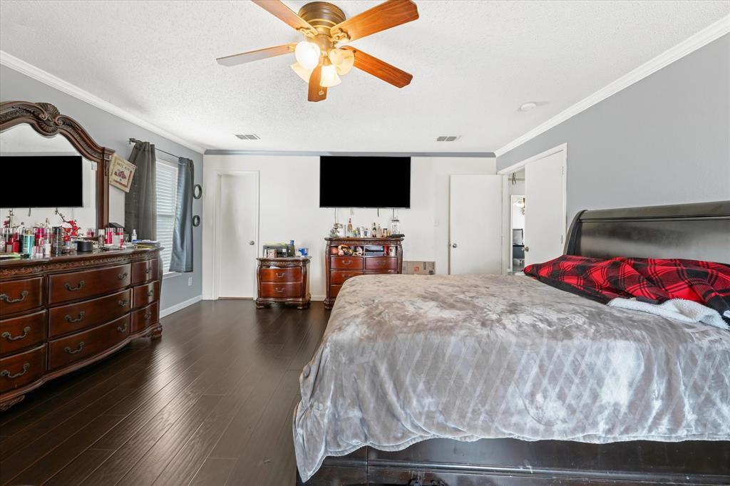 1818 Cedar Ridge Drive Mesquite, TX 75181 - Photo 14 of 21 Bedroom with dark wood-type flooring, ornamental molding, ceiling fan, and a textured ceiling