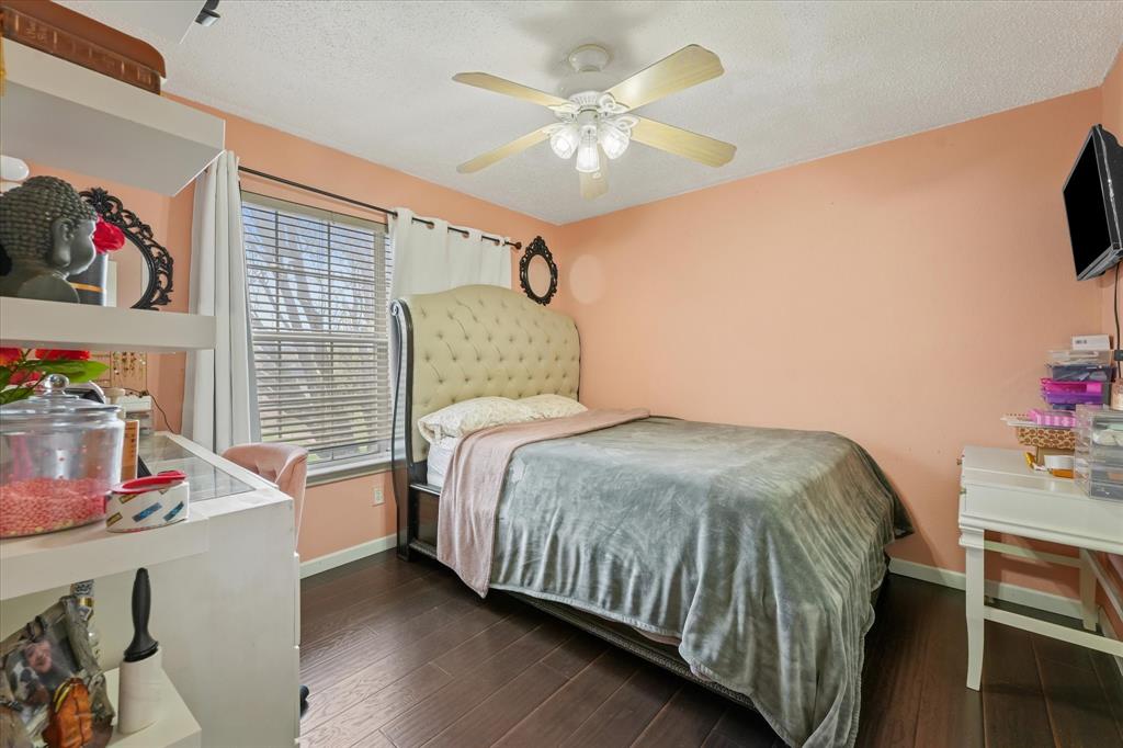 1818 Cedar Ridge Drive Mesquite, TX 75181 - Photo 16 of 21 Bedroom with dark wood-style flooring, ceiling fan, and a textured ceiling