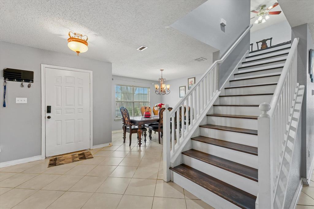 1818 Cedar Ridge Drive Mesquite, TX 75181 - Photo 4 of 21 Foyer with a textured ceiling, hanging lights, light tile patterned flooring, and ceiling fan