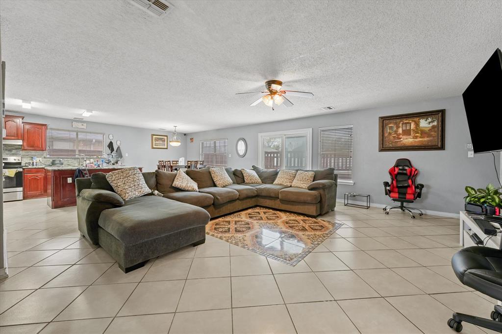 1818 Cedar Ridge Drive Mesquite, TX 75181 - Photo 6 of 21 Living area featuring ceiling fan, a textured ceiling, light tile patterned floors, and suspended lighting
