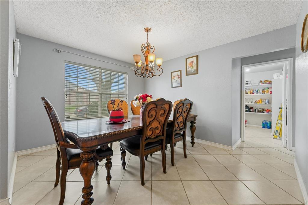 1818 Cedar Ridge Drive Mesquite, TX 75181 - Photo 7 of 21 Dining room with a textured ceiling, a chandelier, and light tile patterned floors