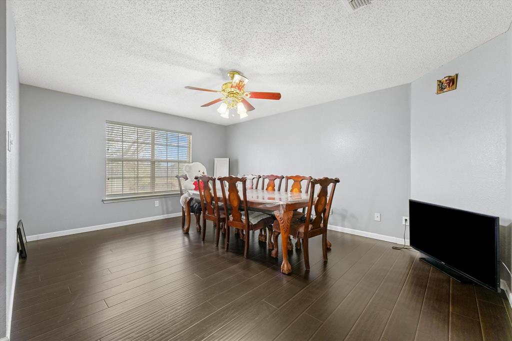 1818 Cedar Ridge Drive Mesquite, TX 75181 - Photo 8 of 21 Dining area featuring a textured ceiling, dark wood-style floors, and a ceiling fan