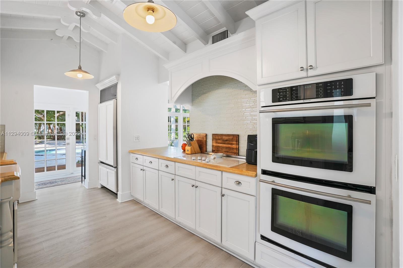 1701 Micanopy Avenue Miami, FL 33133 - Photo 12 of 46 a kitchen with stainless steel appliances a stove a microwave and cabinets