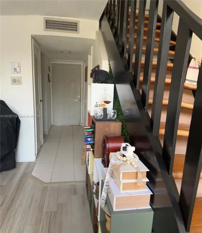 a view of a hallway with furniture and wooden floor