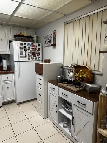 a kitchen with white cabinets and appliances