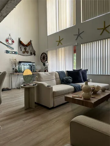 a living room with furniture and kitchen