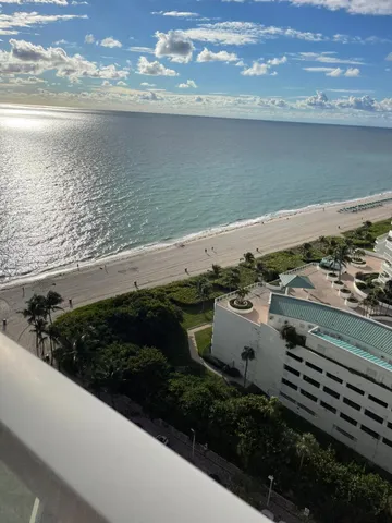 a kitchen with stainless steel appliances kitchen island granite countertop a refrigerator a stove a sink dishwasher and white cabinets with wooden floor