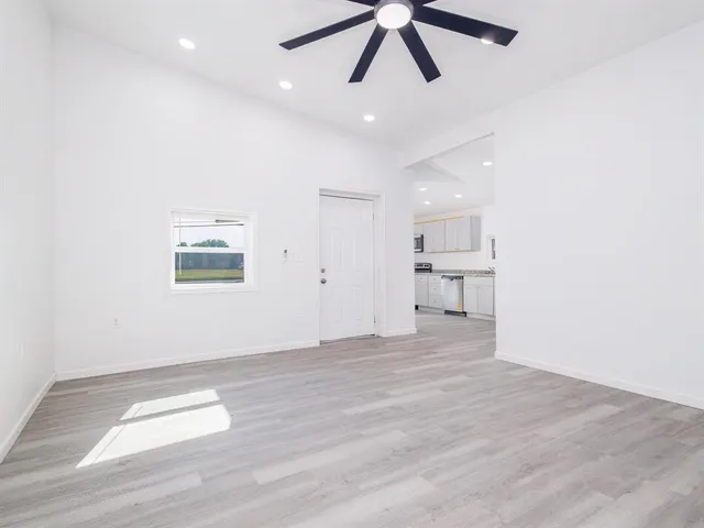 a view of empty room with wooden floor and window
