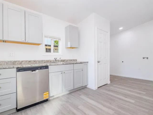 a hallway with granite countertop white cabinets and sink