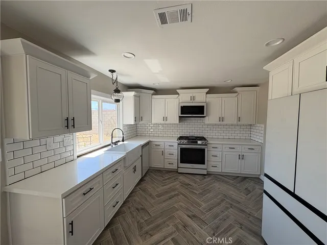 a large kitchen with cabinets stainless steel appliances and a counter space