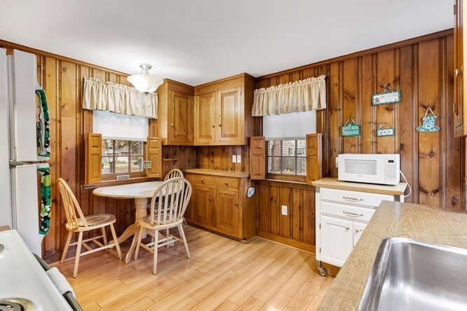 115 Quinn Road Lynn, MA 01904 - Photo 4 of 38 a kitchen with stainless steel appliances granite countertop a stove top oven a refrigerator and dining table with wooden floor