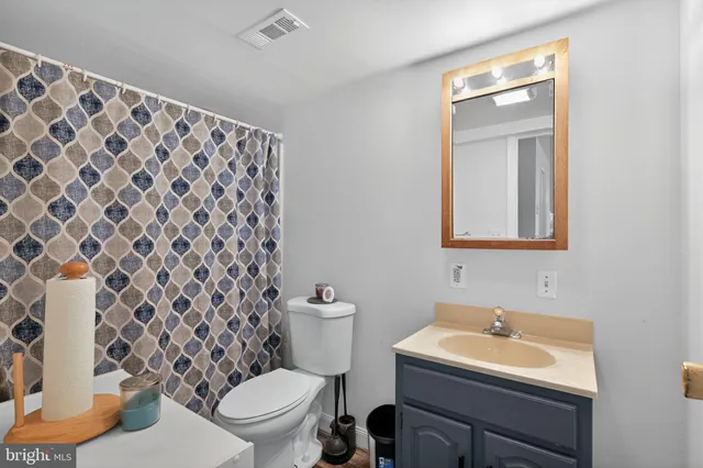 a bathroom with a sink toilet and mirror