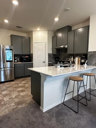 a kitchen with kitchen island a counter top space cabinets and stainless steel appliances