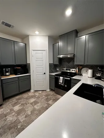 a kitchen with granite countertop a stove and a refrigerator