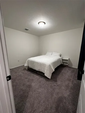 a bedroom with a bed and a night stand