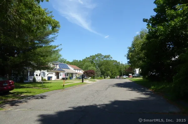 a view of street with houses and trees in the background