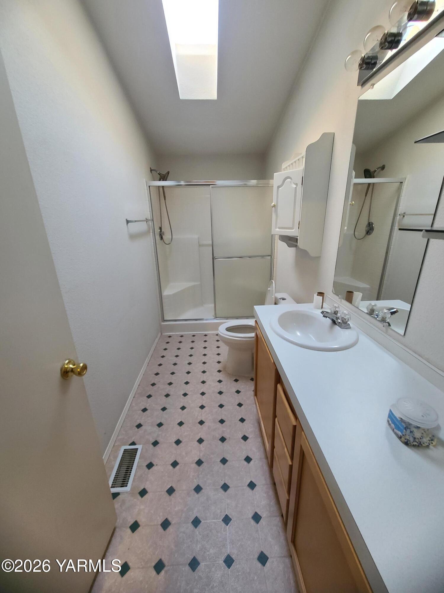 10608 Hackett Road Yakima, WA 98903 - Photo 19 of 25 a bathroom with a sink a toilet a mirror and shower