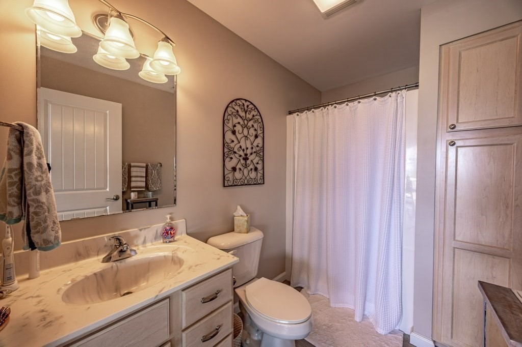 91 Balsam Street Fairhaven, MA 02719 - Photo 25 of 39 a bathroom with a sink a toilet and shower curtain