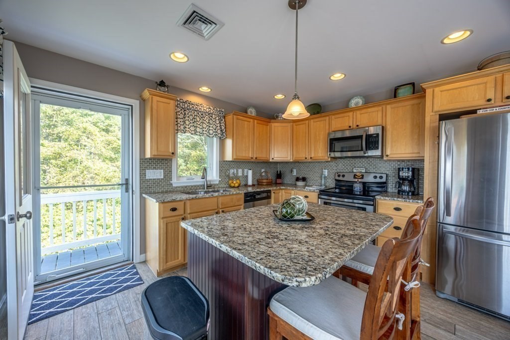 91 Balsam Street Fairhaven, MA 02719 - Photo 34 of 39 a kitchen with kitchen island a large counter top space appliances and a window