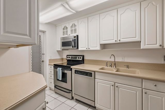 a kitchen with white cabinets and white appliances