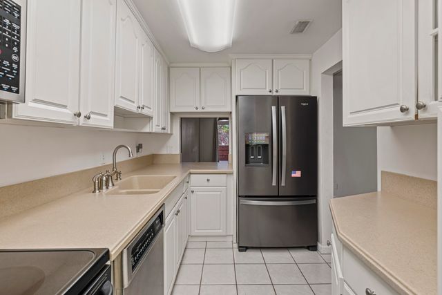 a kitchen with a refrigerator sink and cabinets