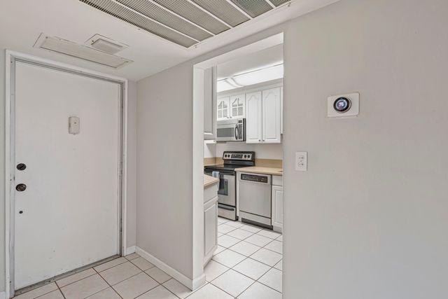 a kitchen with a refrigerator and white cabinets