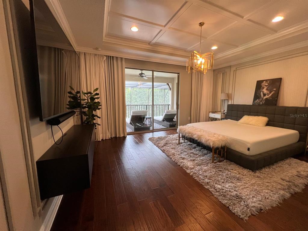 12927 Canopy Woods Way Winter Garden, FL 34787 - Photo 20 of 41 a spacious bedroom with a large bed and a flat tv screen