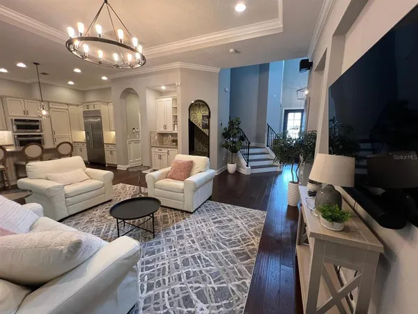 a living room with furniture a flat screen tv and kitchen view