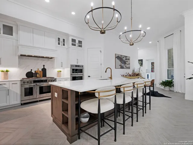 a kitchen with stainless steel appliances a table chairs and a refrigerator