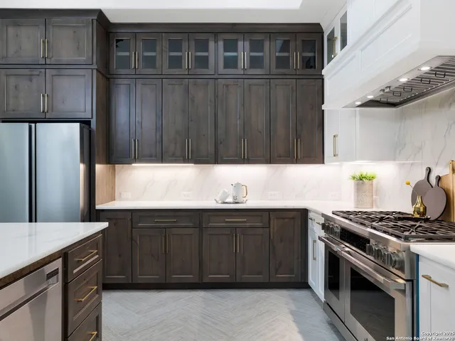 a kitchen with stainless steel appliances a stove a sink and a refrigerator
