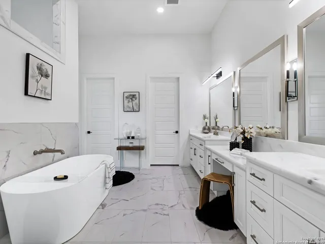 a bathroom with a double vanity sink mirror and bathtub