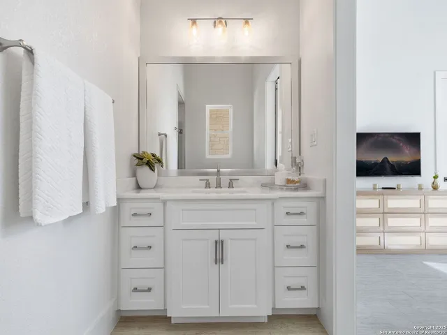 a bathroom with a sink a mirror and cabinets