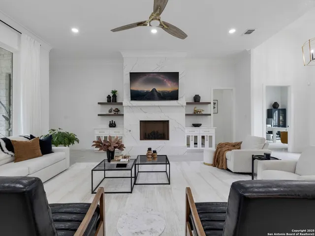 a living room with furniture a flat screen tv and a fireplace