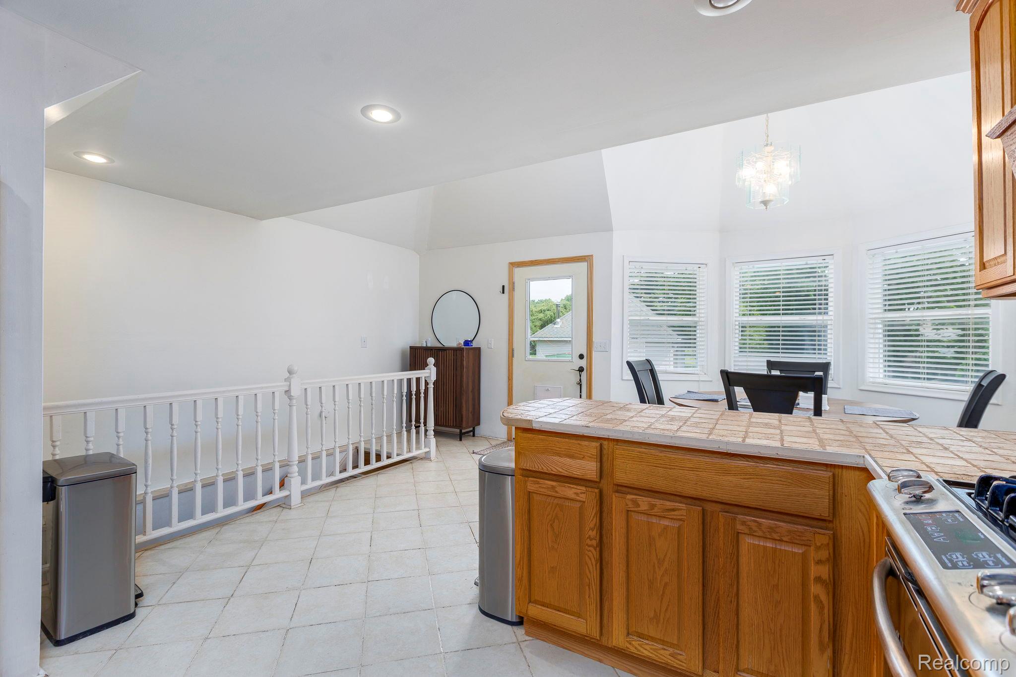 401 Pointe Tremble Road Algonac, MI 48001 - Photo 19 of 40 Kitchen island featuring wood cabinetry and a tiled countertop, alongside a dining area with multiple windows