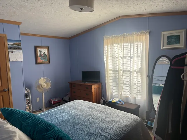 a bedroom with a bed and a lamp next to a window