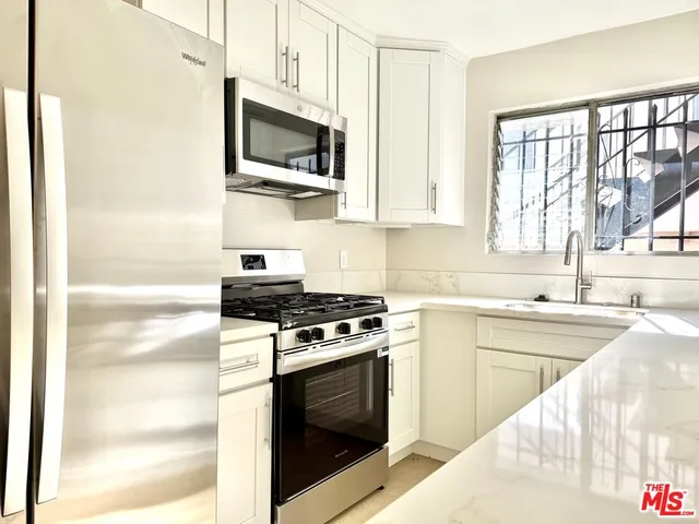 a kitchen with stainless steel appliances a stove a sink and a microwave