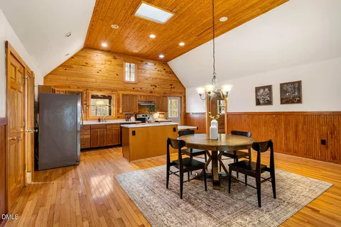 a dining room with furniture a chandelier and wooden floor