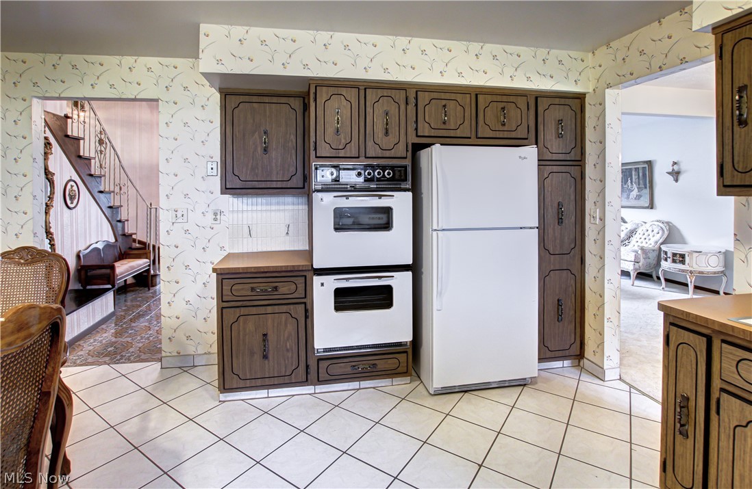 6013 Rousseau Drive Parma, OH 44129 - Photo 4 of 50 Kitchen with white appliances, tasteful backsplash, and light tile floors