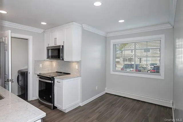 a view of kitchen with wooden floor electronic appliances and window