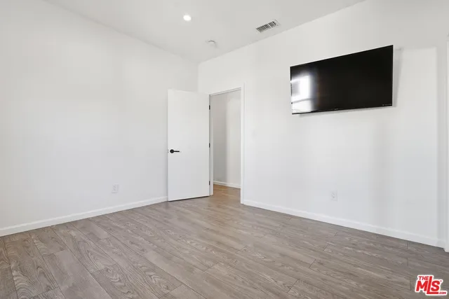 a view of a livingroom with wooden floor and a flat screen tv