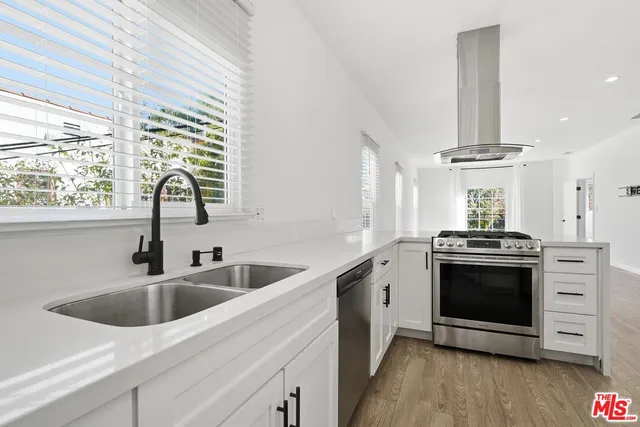 a kitchen with stainless steel appliances a sink a stove and a window