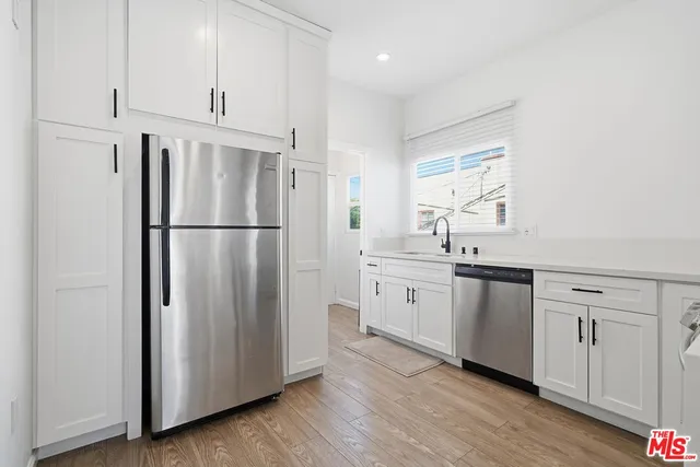 a kitchen with stainless steel appliances a refrigerator sink and cabinets