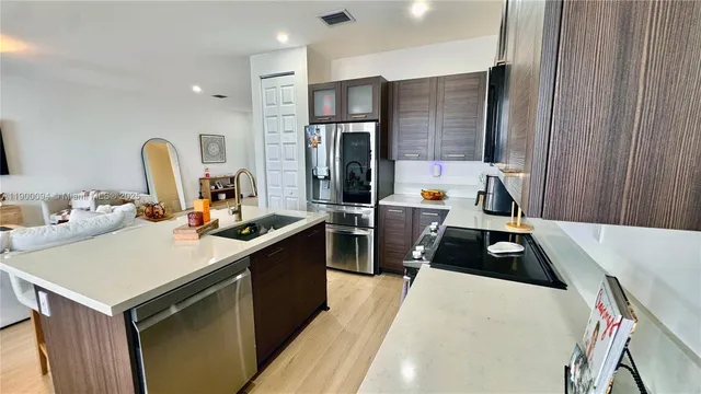 a kitchen with a refrigerator a sink and wooden cabinets